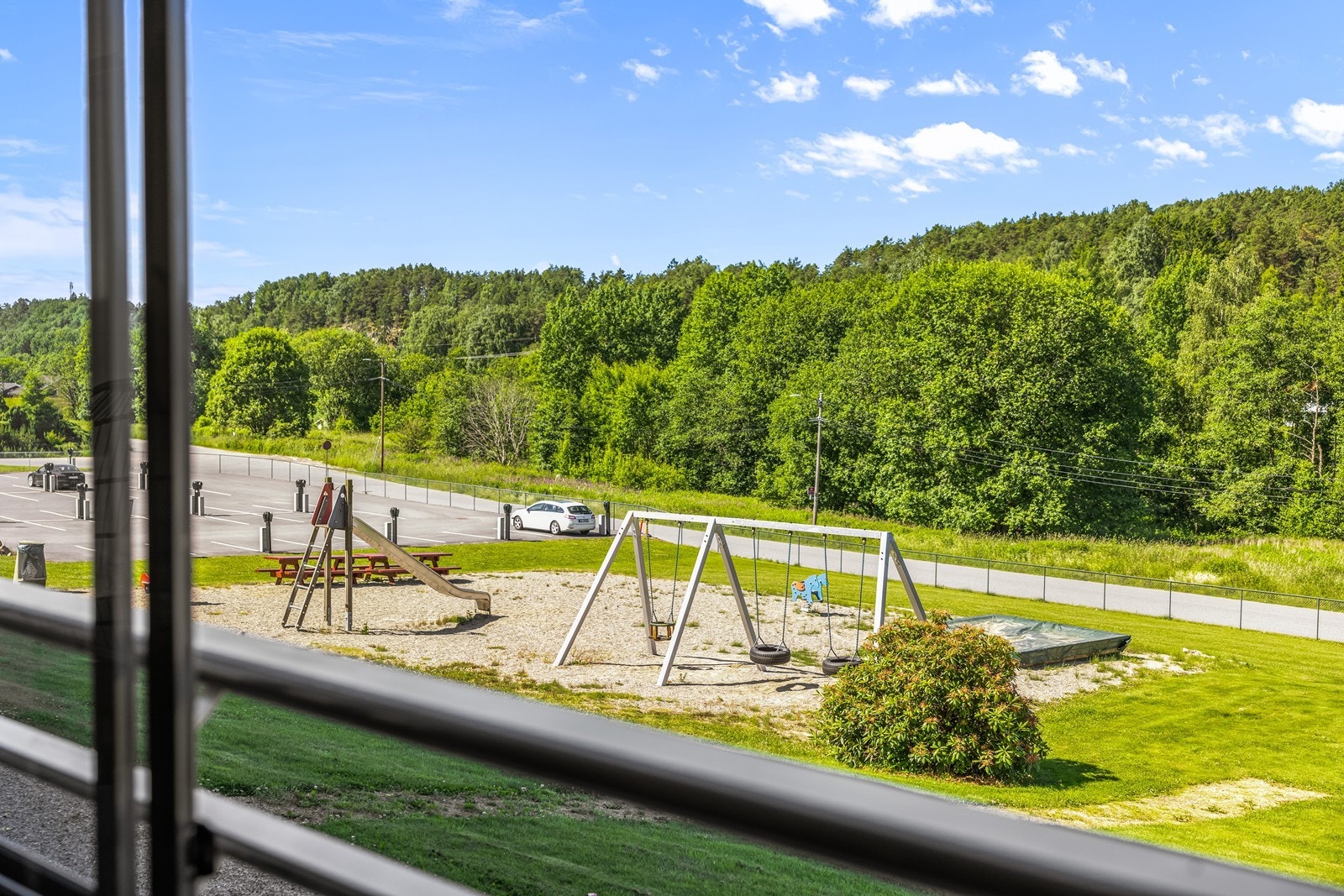 Fra leilighetens balkong er det direkte utsyn til lekeplassen og grøntområdene. Galleribilde