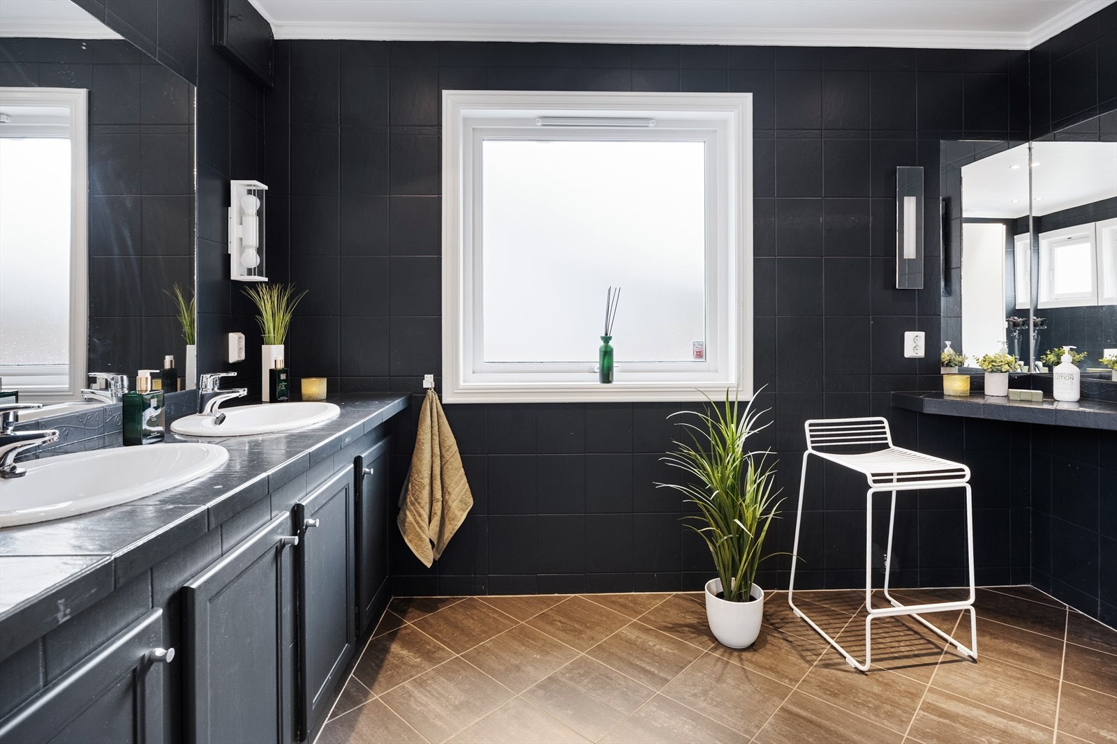 Det romslige badet i 1. etasje har fliser på vegger og gulv, hvor veggflisene er overflatebehandlet med maling Galleribilde