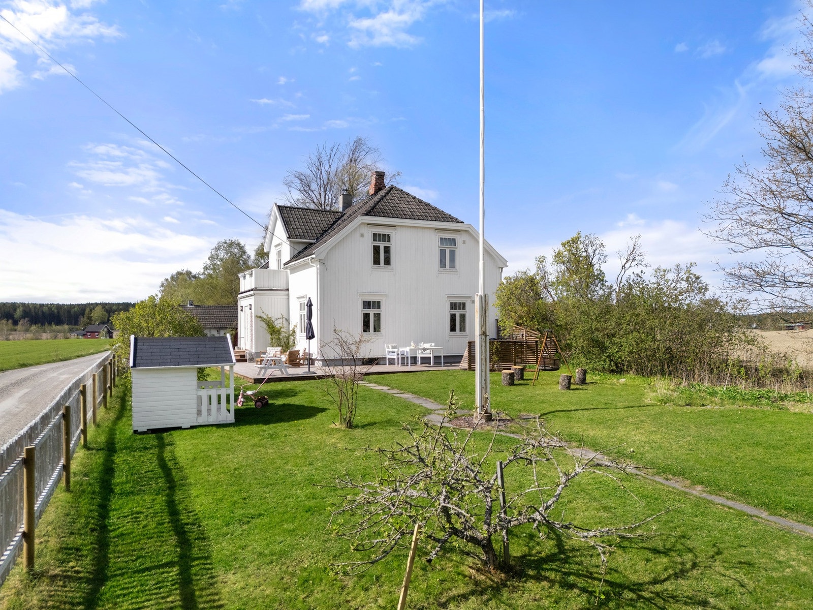 Tomten er pent opparbeidet med plen, beplantning og åpne arealer. Galleribilde