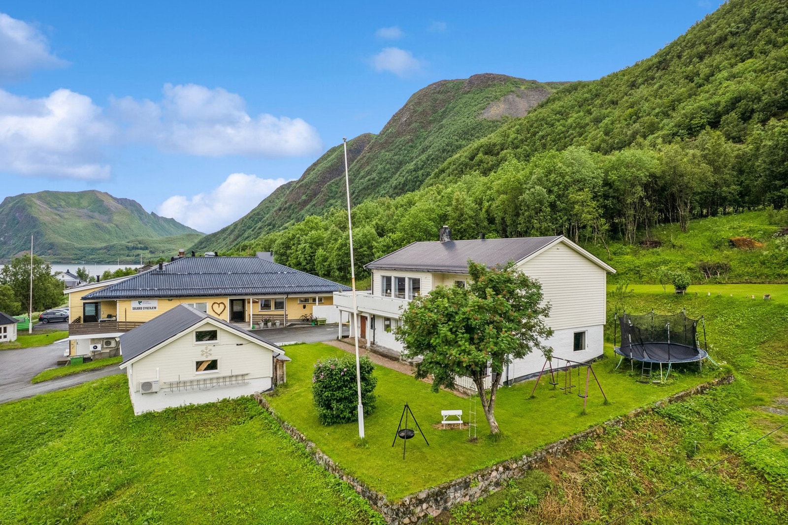 Tomten er opparbeidet med plen og parkeringsareal. Galleribilde