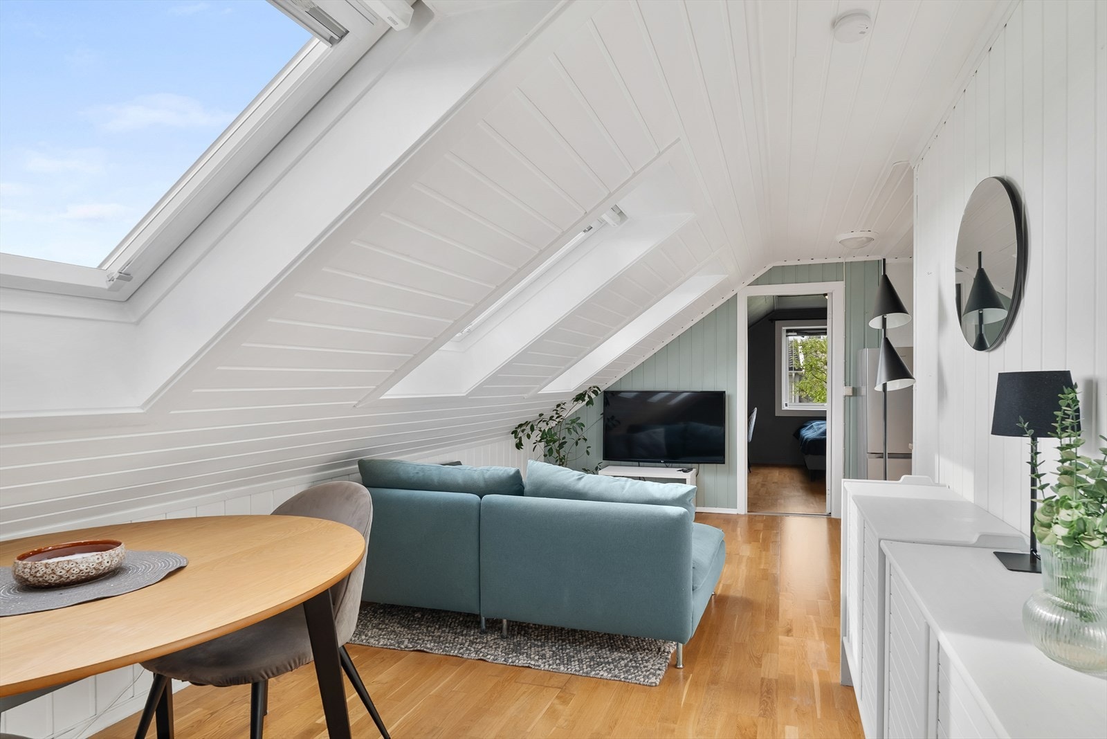 Lys stue med Velux-vinduer som slipper inn rikelig med dagslys Galleribilde