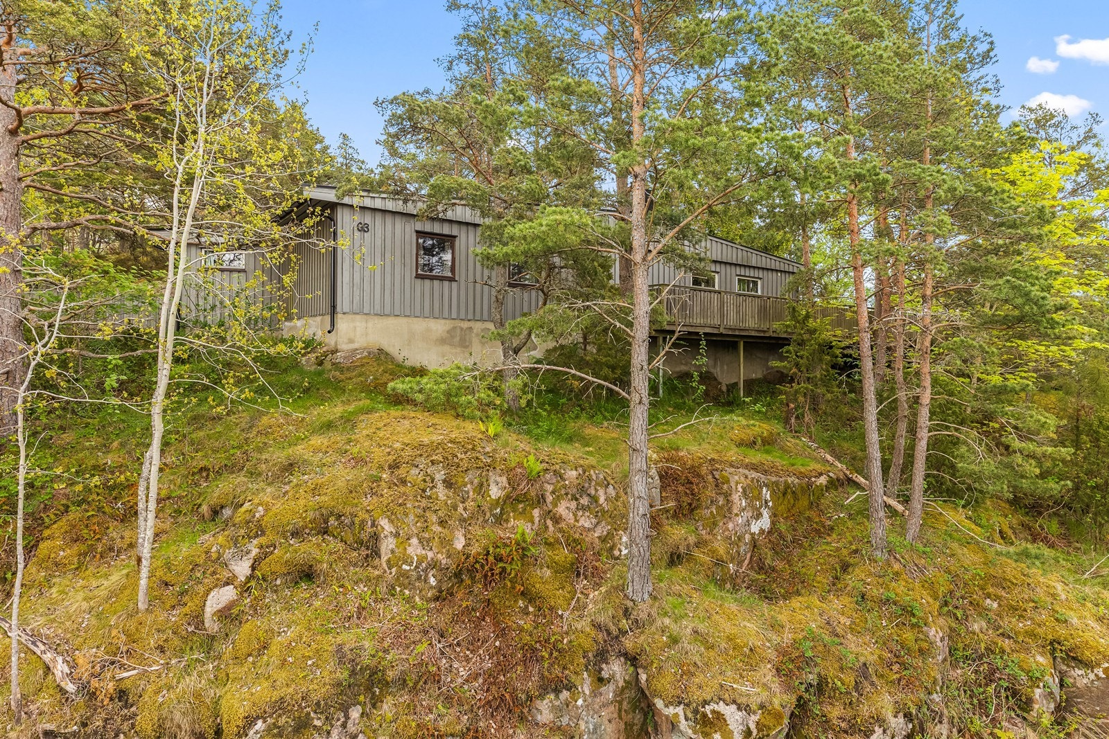 Eiendommen ligger flott til i grønne og naturpregede omgivelser, hvor trær og naturlig vegetasjon skaper en skjermet og privat atmosfære. Galleribilde