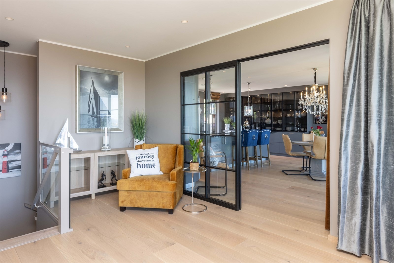 Stilfull smijernsskyvedør i sort utførelse skaper en elegant overgang mellom stue og kjøkken, samtidig som rommene enkelt kan skilles av ved behov Galleribilde