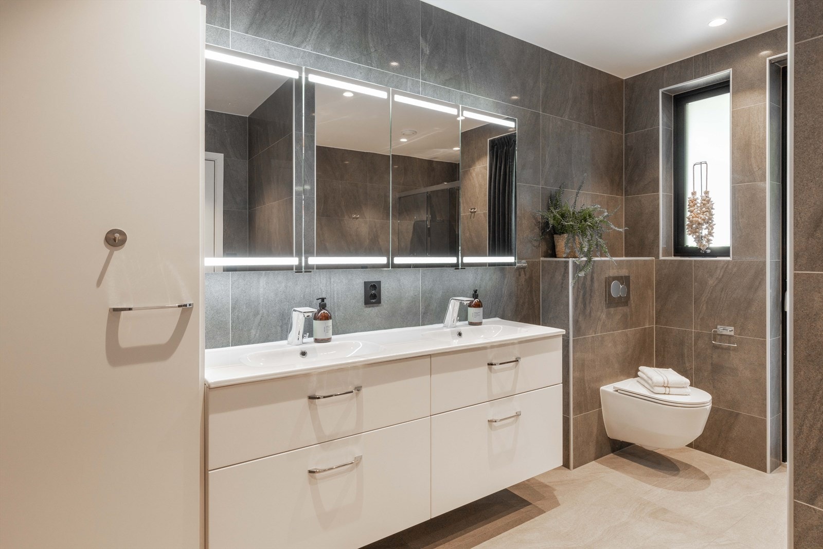 Hovedbadet i andre etasje er romslig og innredet med blant annet 180 cm badekar, Hansgrohe armaturer, berøringsfrie kraner og store flislagte flater med epoxyfuger. Galleribilde