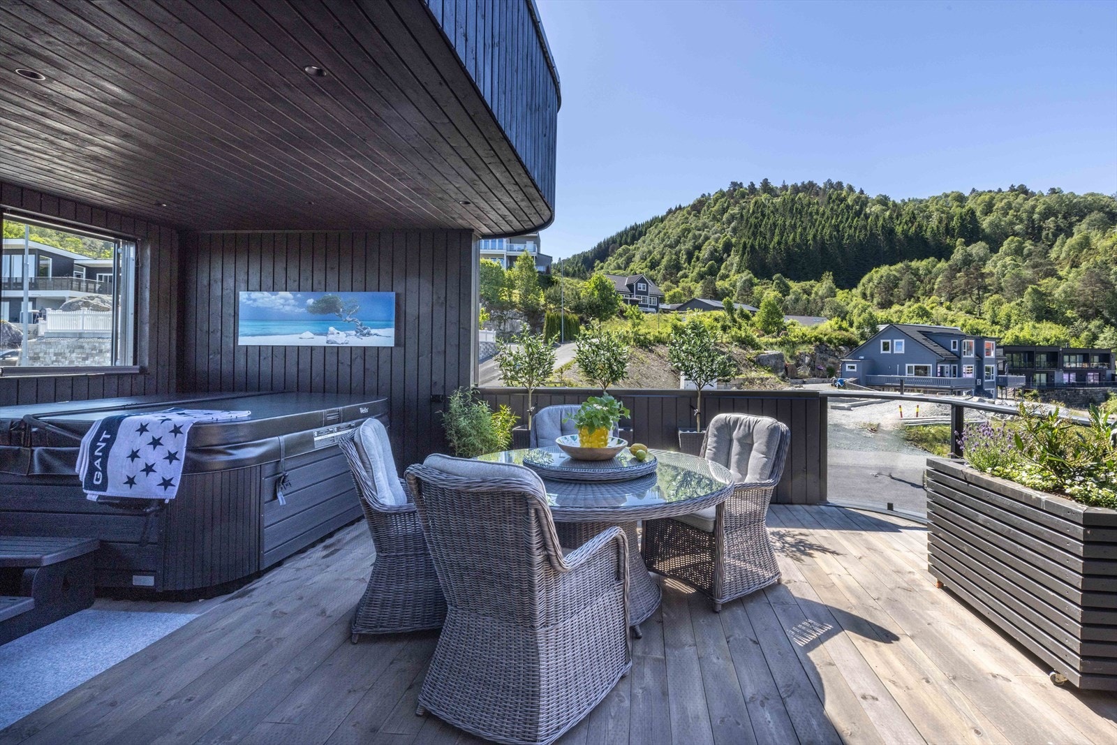 Den delvis overbygde terrassen med jacuzzi fremstår som en naturlig forlengelse av boligens oppholdsrom og skaper en skjermet oase med høy trivselfaktor. Galleribilde