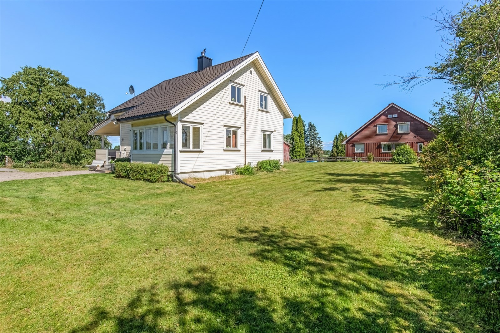 Tomten er pent opparbeidet med gressplen og beplantning. Galleribilde