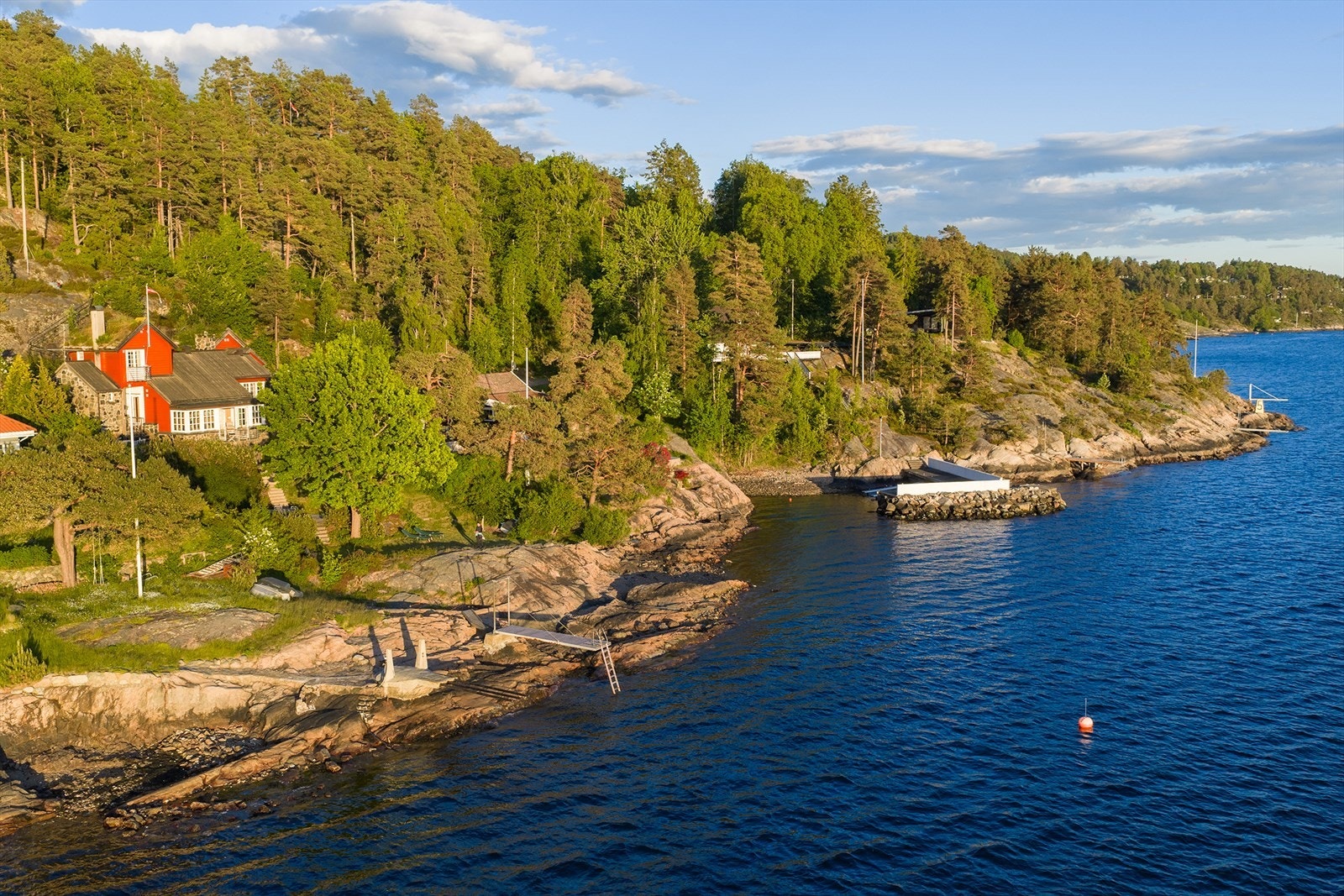 Eiendommen har egen strandlinje, båtbøyer og brygge perfekt for bading. Galleribilde