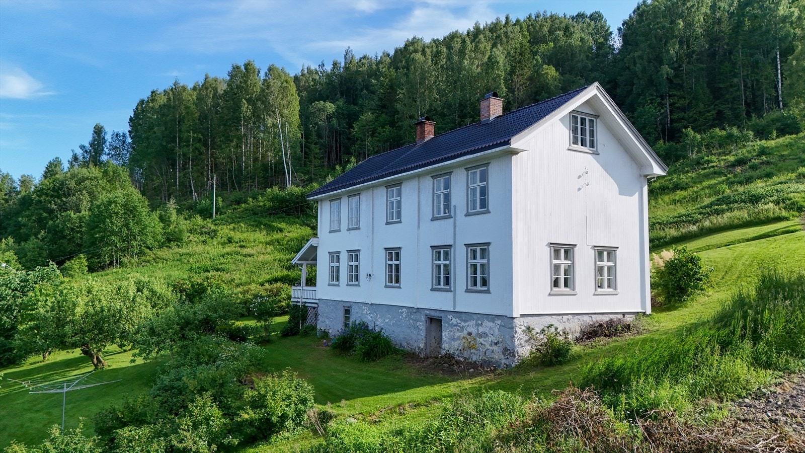 Elegant våningshus omgitt av grønne hager og natur. Foto-Olsen Galleribilde