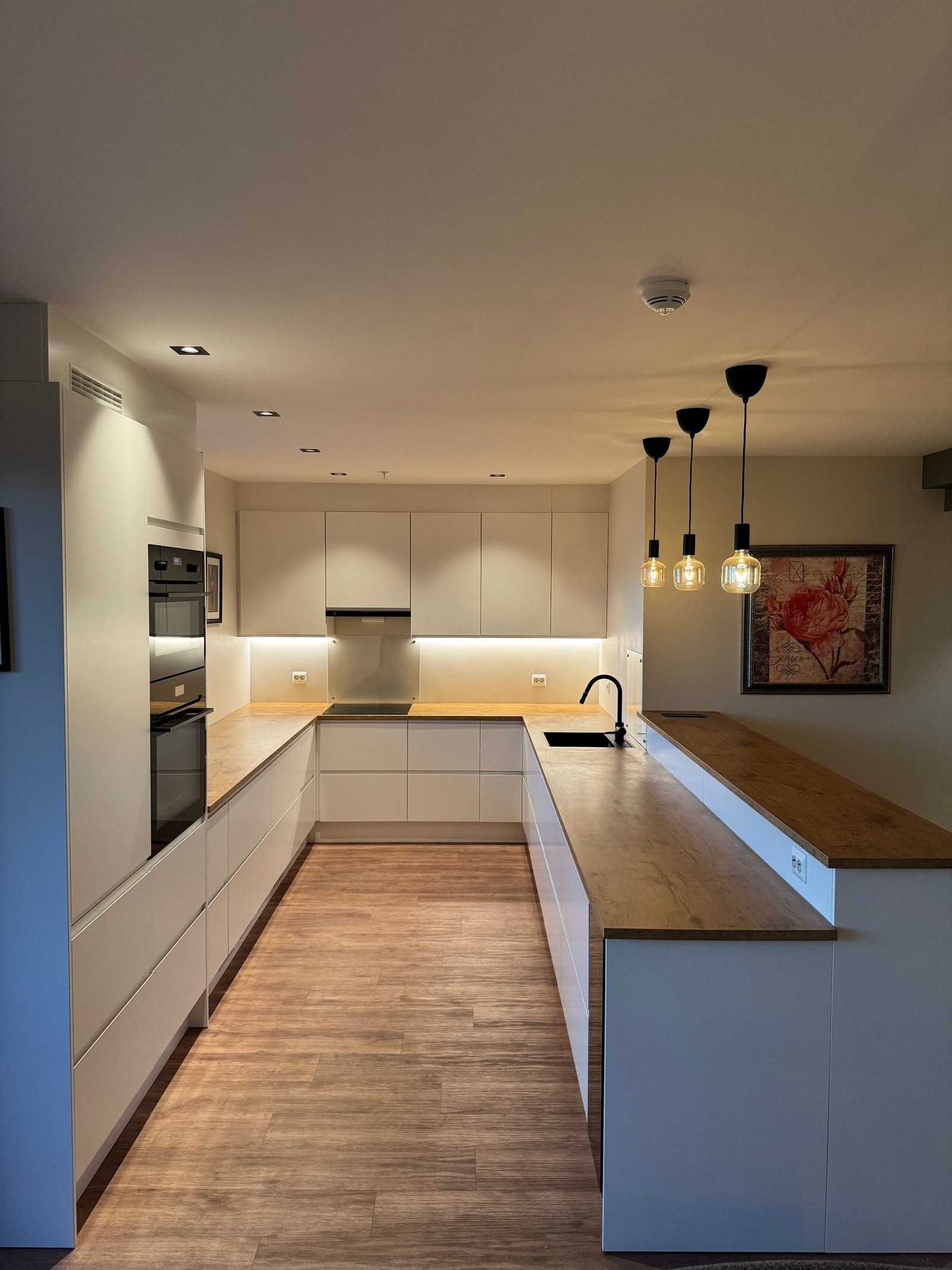 Moderne helhet med integrerte løsninger og en elegant kombinasjon av hvitt og treverk. Galleribilde