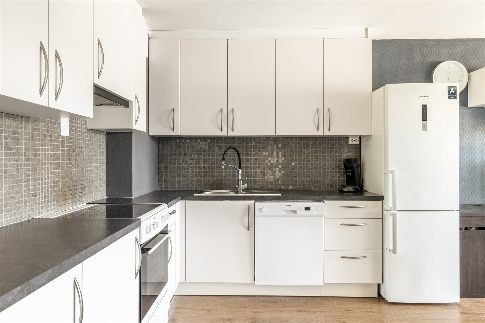 Kjøkkenet har avsatt plass til frittstående hvitevarer som oppvaskmaskin, komfyr og kjøl/fryseskap, og over kokesonen er det ventilator med kullfilter samt mekanisk ventilasjon via ventil i vegg. Galleribilde