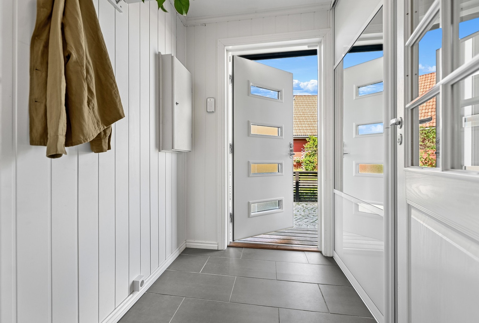 Vel inne gir entreen et godt førsteinntrykk, med varmekabler, grå gulvfliser og hvitmalte panelplater. Galleribilde
