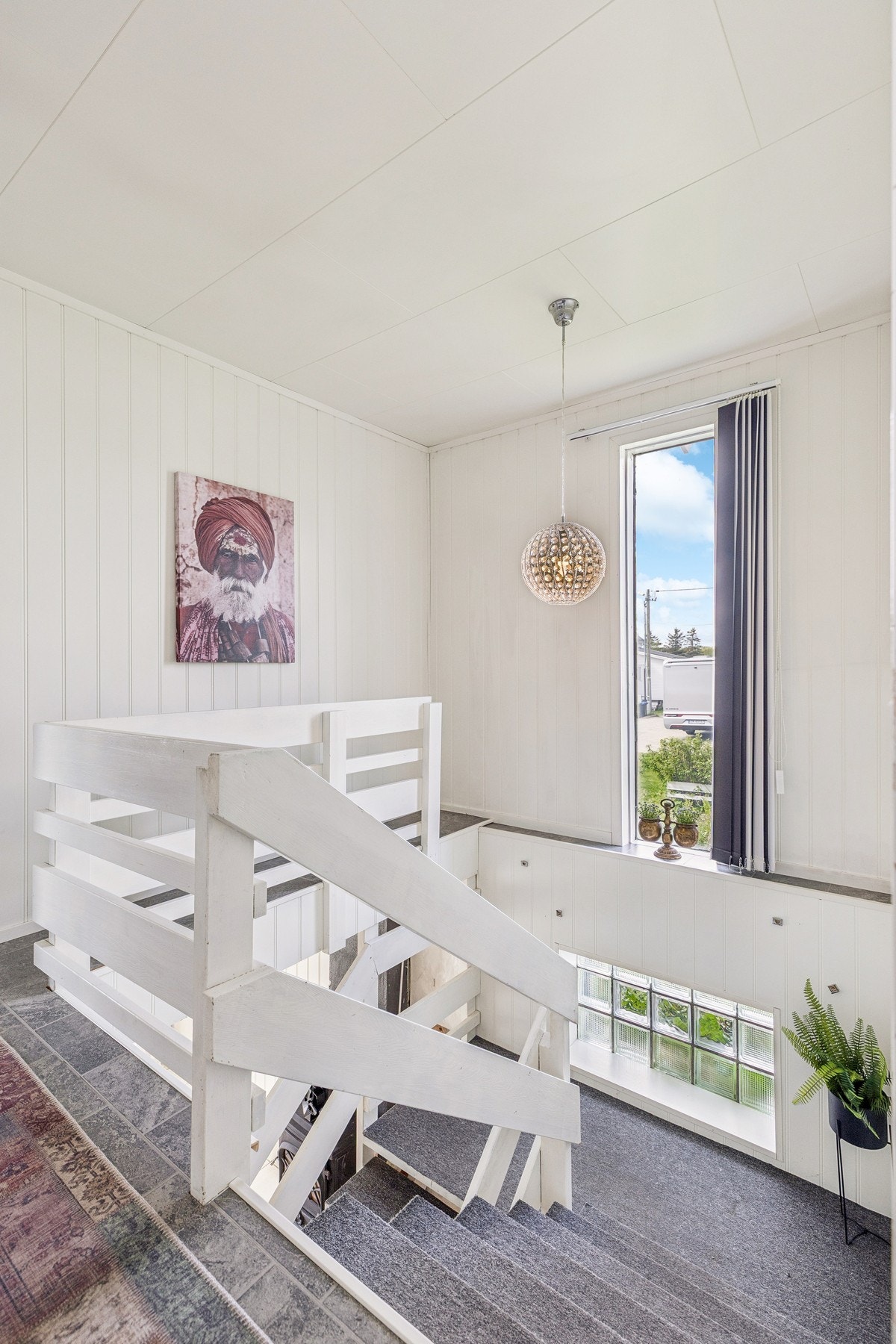 Trapperom med godt lysinnslipp fra et stort vindu. Galleribilde