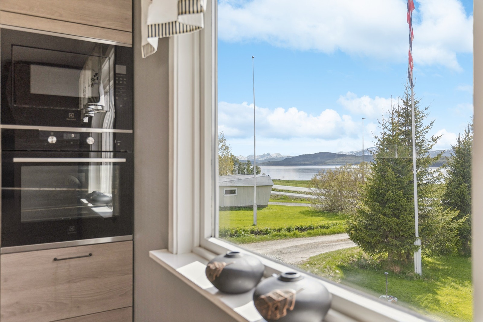 Fra kjøkkenvinduet er det utsikt mot sjøen og fjellandskapet. Galleribilde
