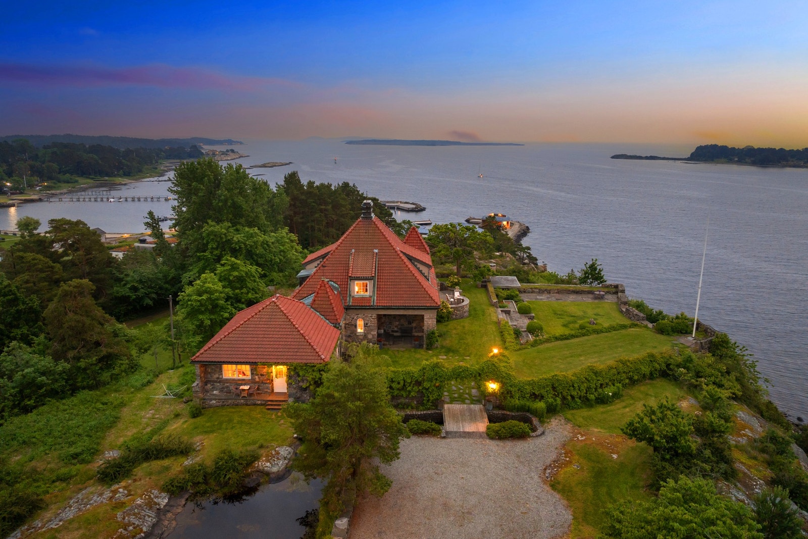 Eiendommen har fantastisk utsikt mot fjorden og er parkmessig opparbeidet med vakre uteområder tilpasset både topografi & bebyggelse Galleribilde