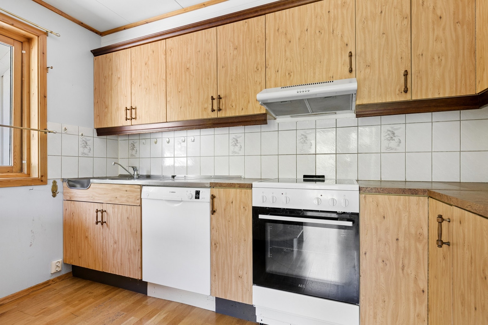 Kjøkkenet er utstyrt med komfyr, ventilator og oppvaskmaskin. Galleribilde