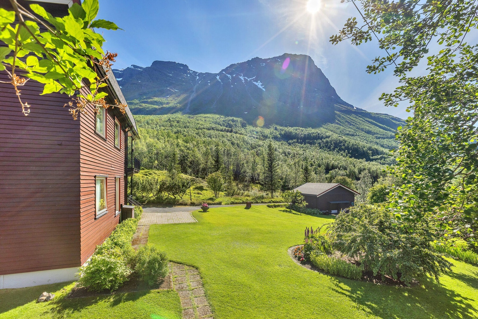 Fra hagen er det utsikt mot fjellene og garasjebygget. Galleribilde
