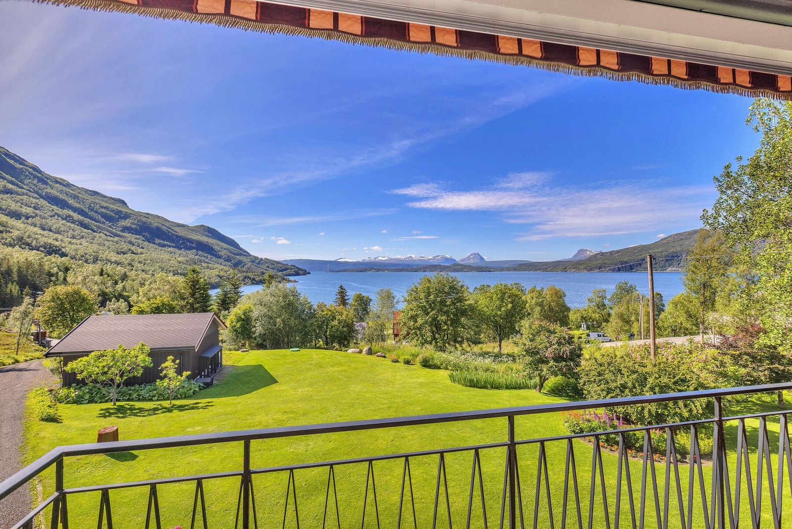 Fra verandaen er det en vidstrakt utsikt over fjorden og det omkringliggende landskapet. Galleribilde