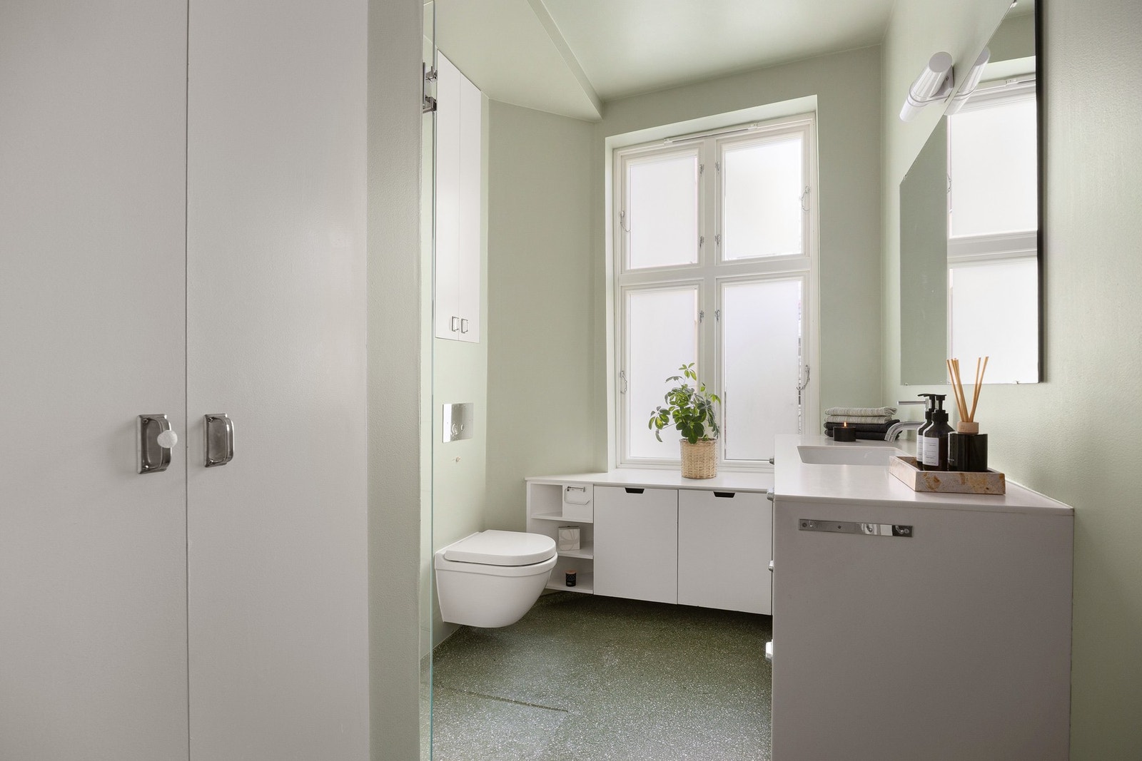 Badet har støpt Terrazzo gulv, med plassbygd oppbevaring og vegghengt toalett Galleribilde