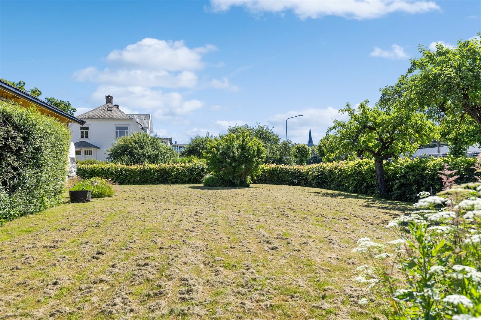 Den grønne beplantningen gir eiendommen et lunt og trivelig preg, samtidig som den bidrar til en naturlig ramme rundt uteområdet. Galleribilde