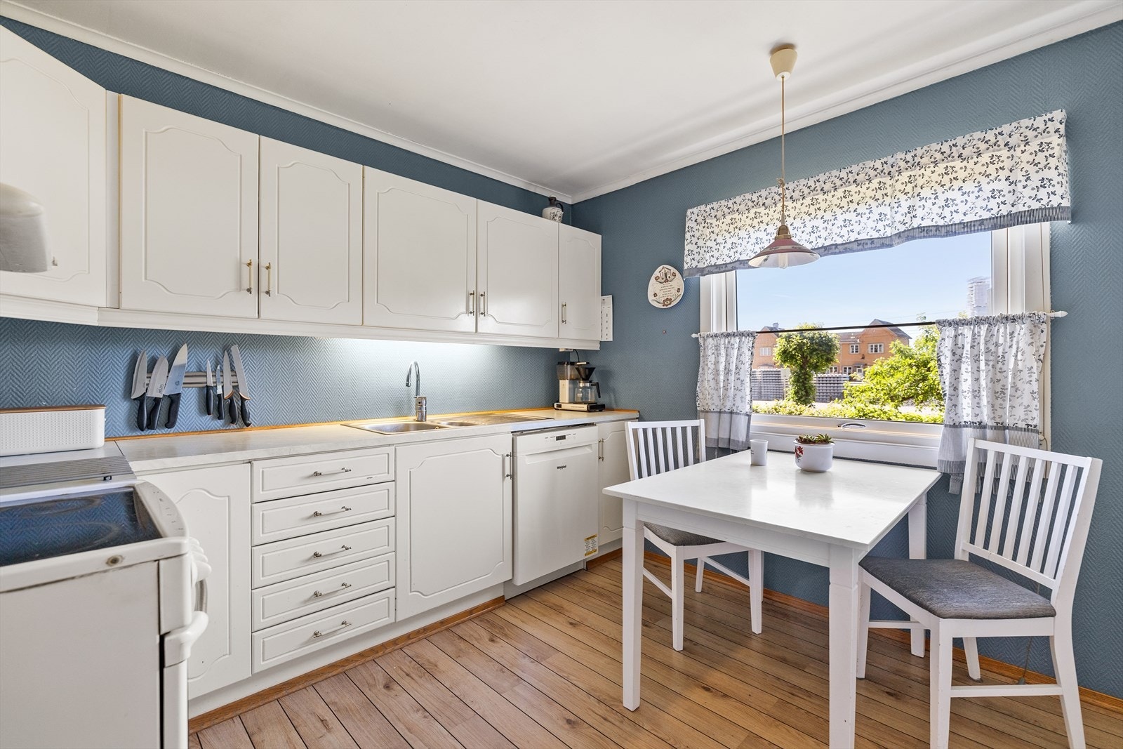 Innredningen har klassiske, profilerte hvite fronter som gir et tidløst uttrykk, og er plassert langs tre vegger slik at du får rikelig med både skap- og benkeplass. Galleribilde