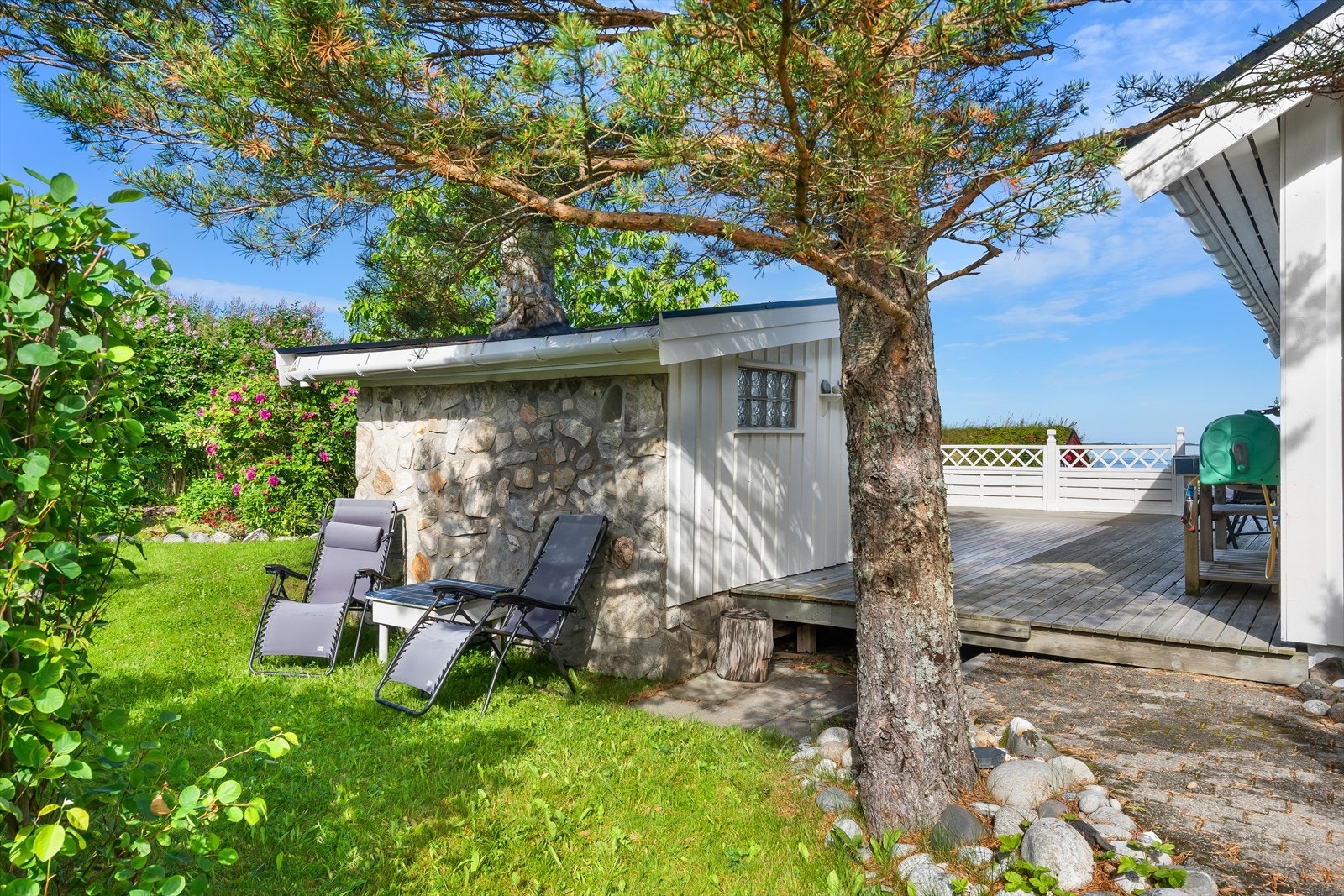 Treplatt og steinmur ved grillhuset gir estetisk og praktisk utemiljø. Galleribilde