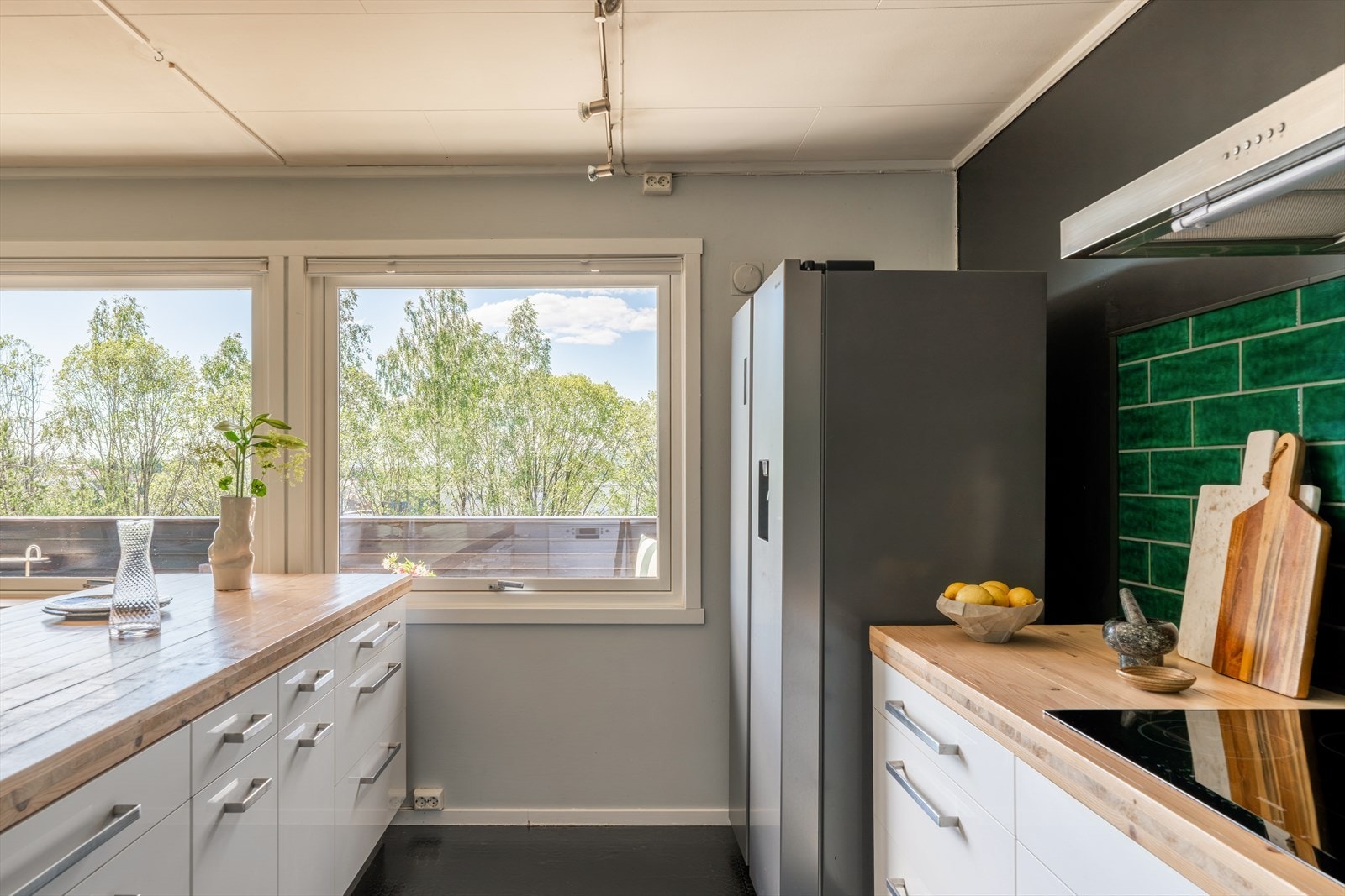 Innredningen består av hvite høyglansfronter fra Ikea, kombinert med benkeplate i heltre og flislagt vegg over benken, utført i løpet av de siste fem årene. Galleribilde
