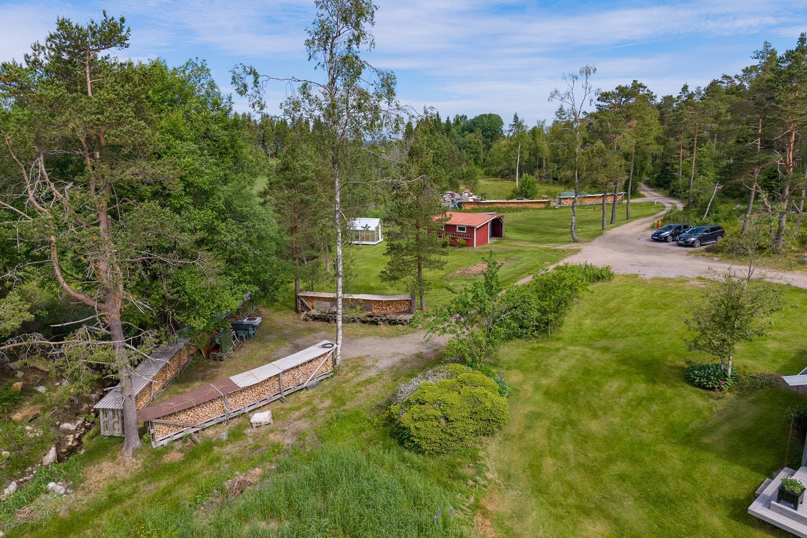 Gruset vei og parkering, store plenarealer og skog Galleribilde
