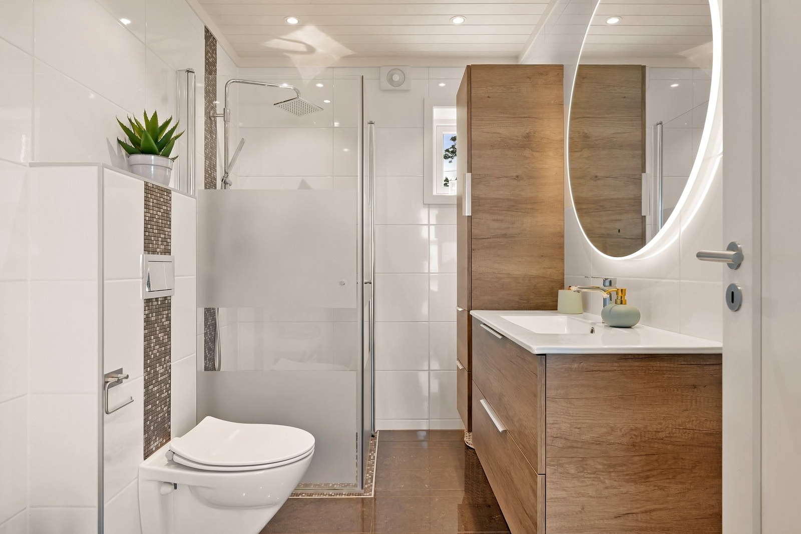 Badet har keramiske fliser på vegger og malt himling. Galleribilde