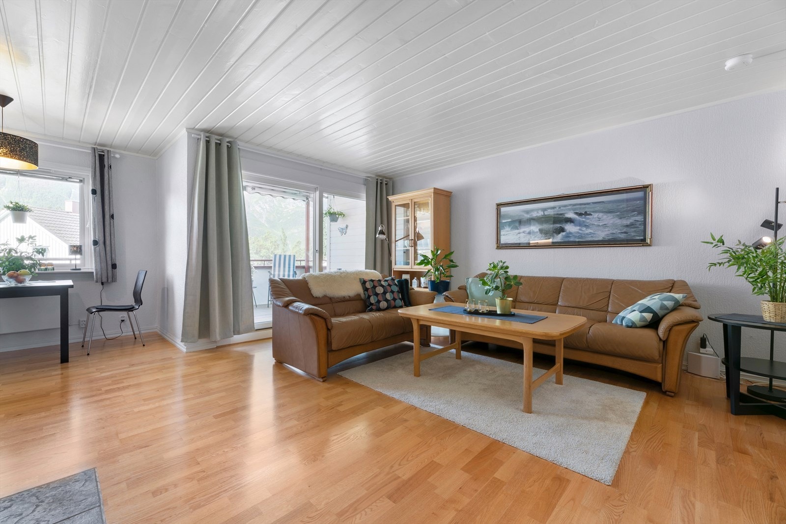 Hyggelig stue som gir plass for både sofagruppe og spisestue. Vinduene mot vest og øst ble utskiftet i 2014. Galleribilde