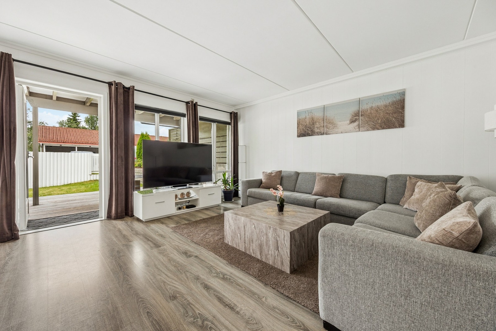Fra stuen er det utgang til terrassen og hagen, noe som gjør rommet til et naturlig midtpunkt i boligen sommerstid. Galleribilde