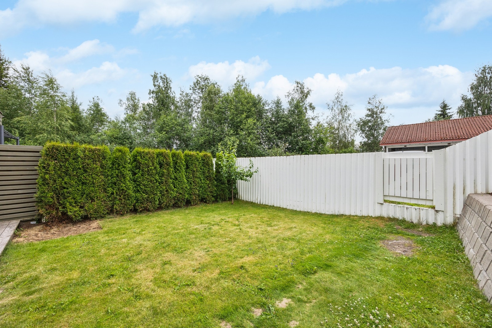 Eiendommen har et hyggelig uteområde med plen og en romslig terrasse på 25 m² i tilknytning til stuen Galleribilde