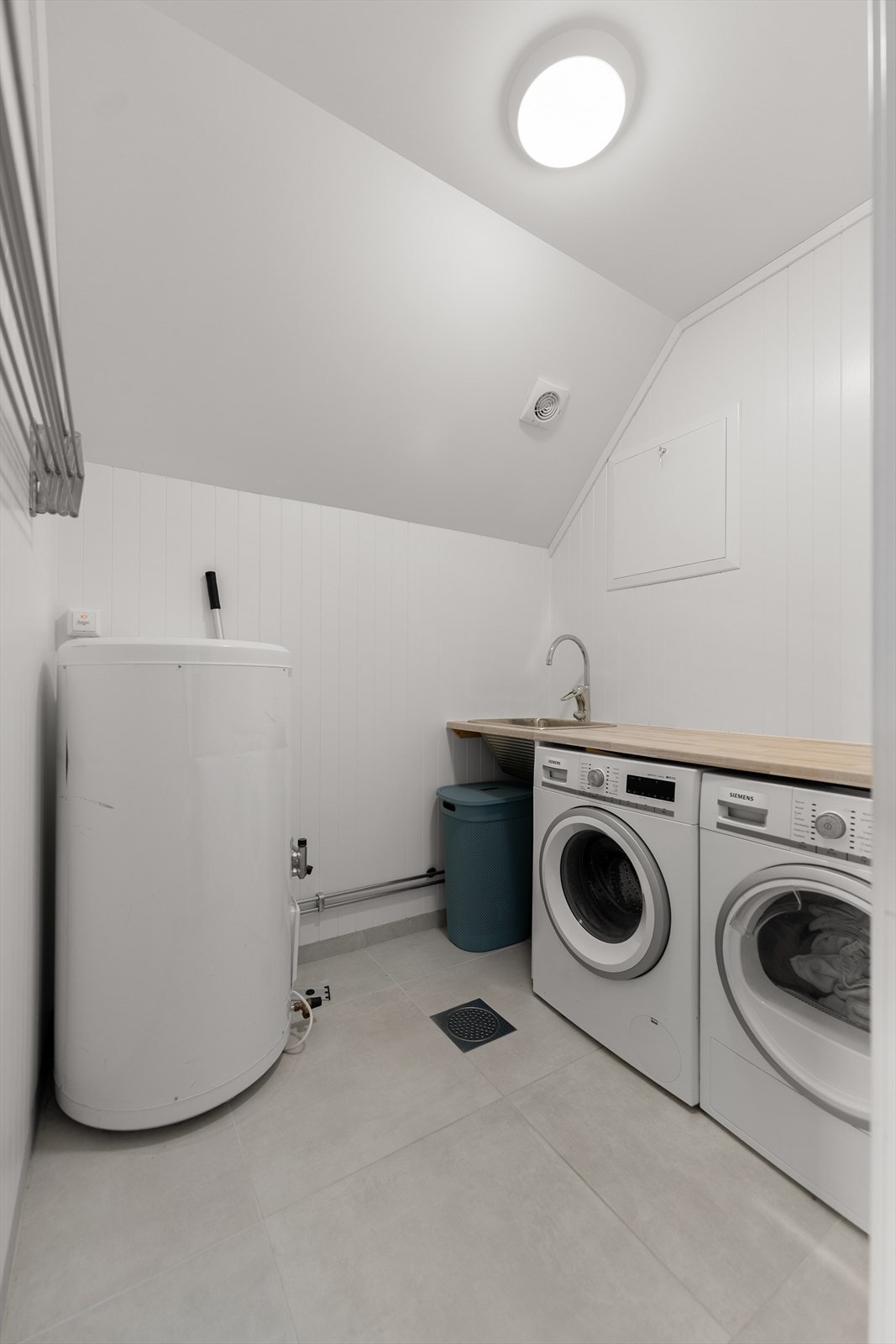 Vaskerom har flislagt gulv med elektriske varmekabler. Rommet har innredning med nedfelt servant og opplegg for vaskemaskin. Galleribilde
