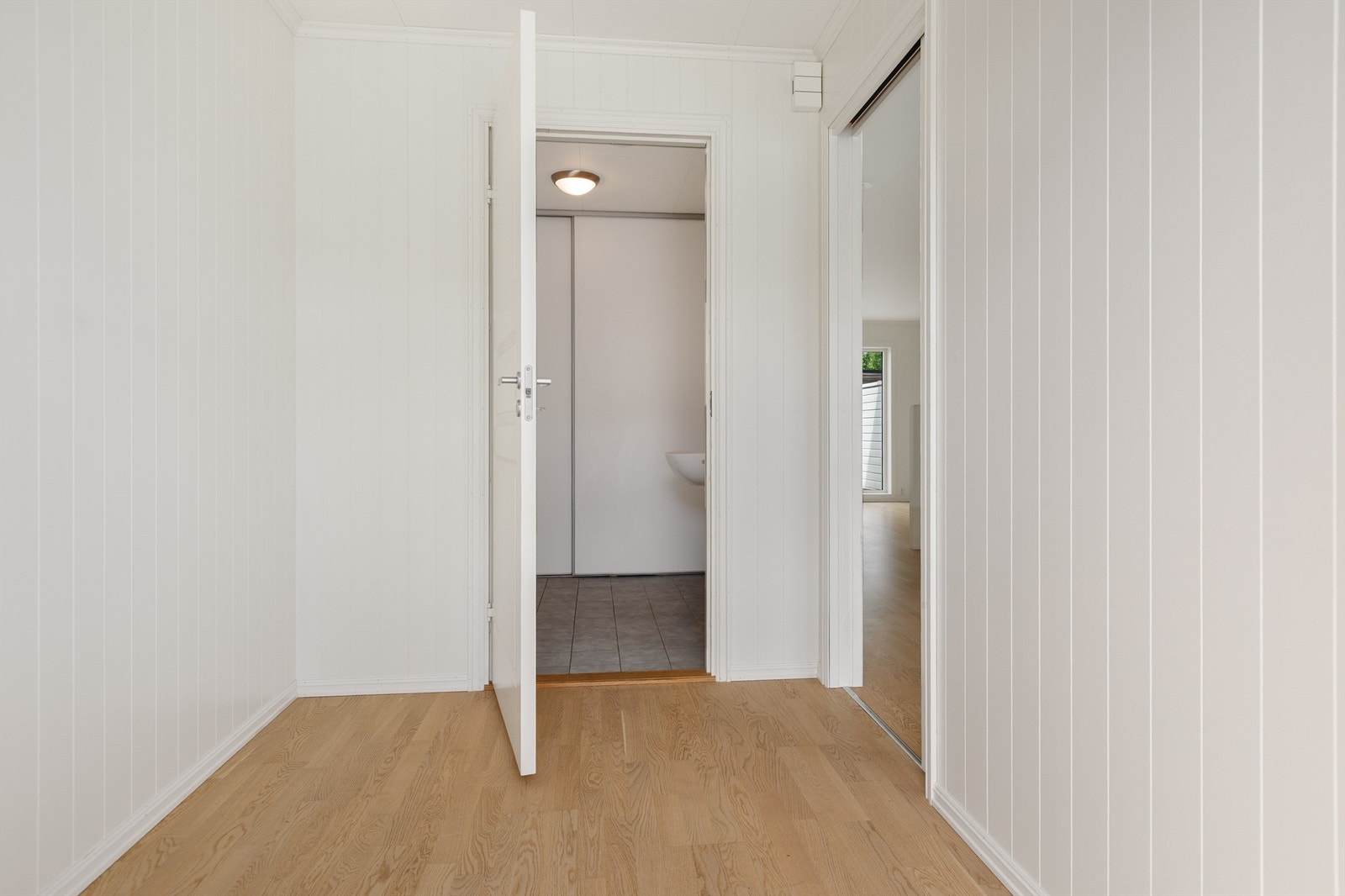 Entreen har dør inn til vaskerom med toalett, og skyvedør inn til kjøkken Galleribilde