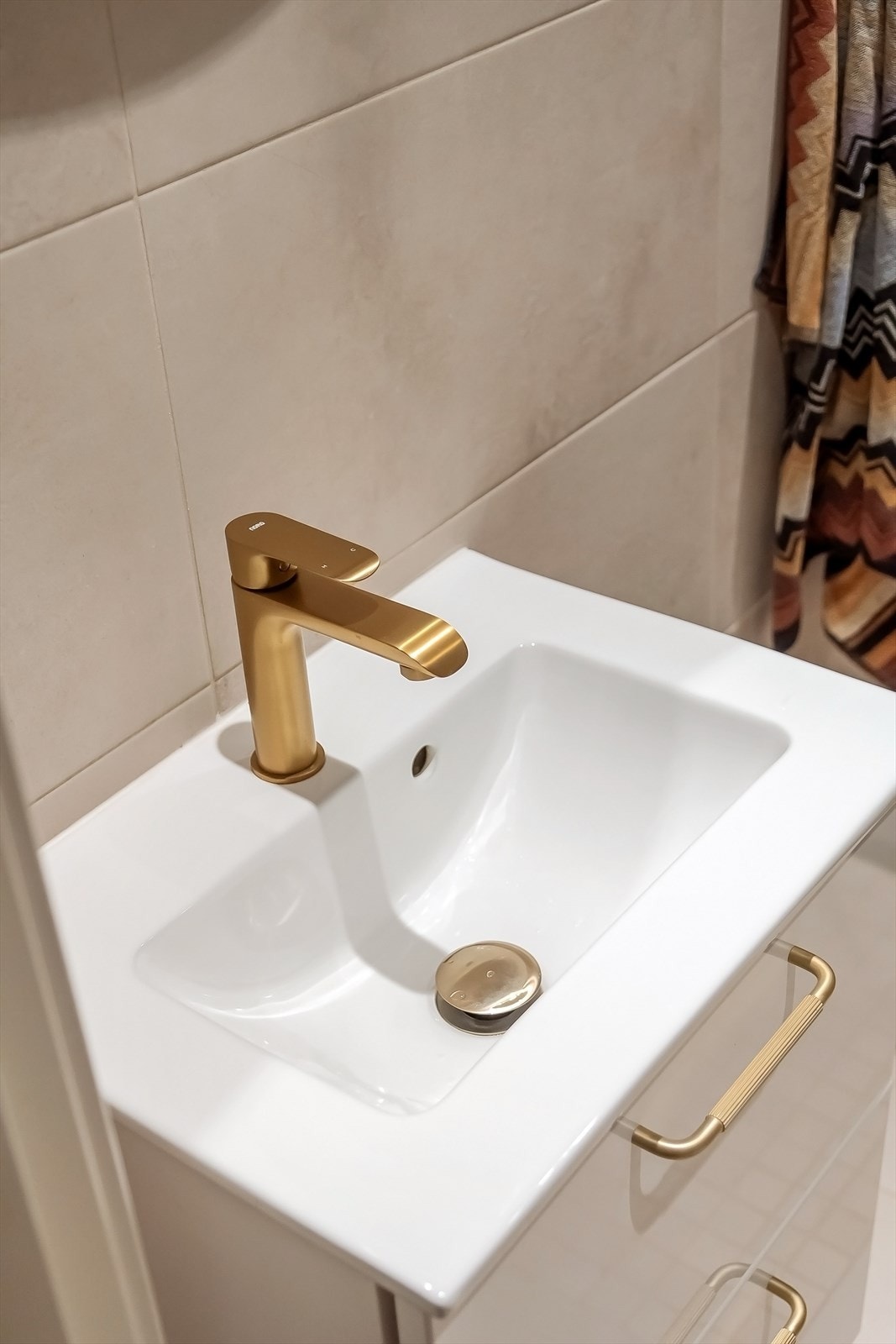 Vakre gulldetaljer som er gjennomgående for badet Galleribilde