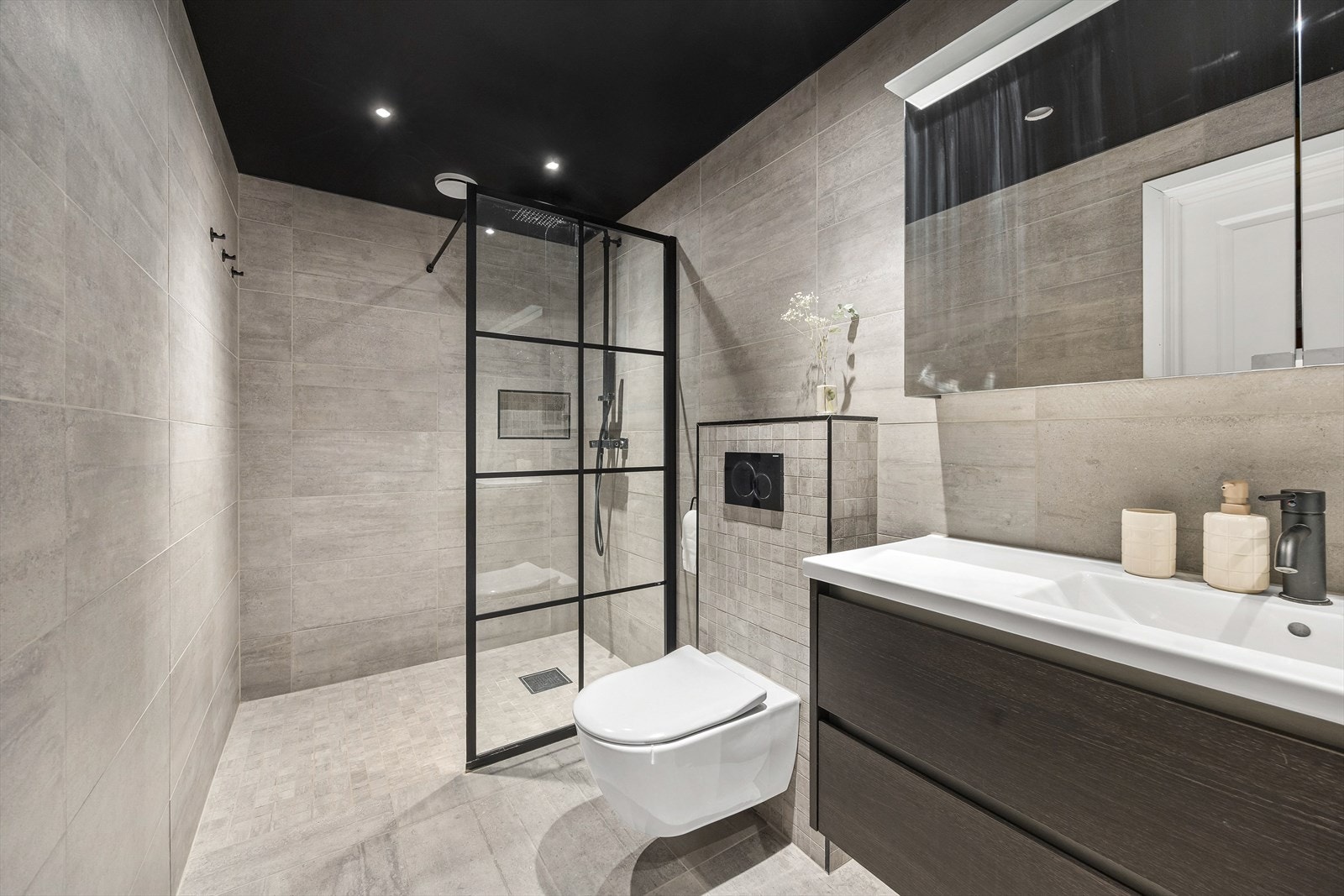 Badet er utstyrt med innredning med servant, speilskap, toalett, dusj på gulv og opplegg for vaskemaskin. Galleribilde