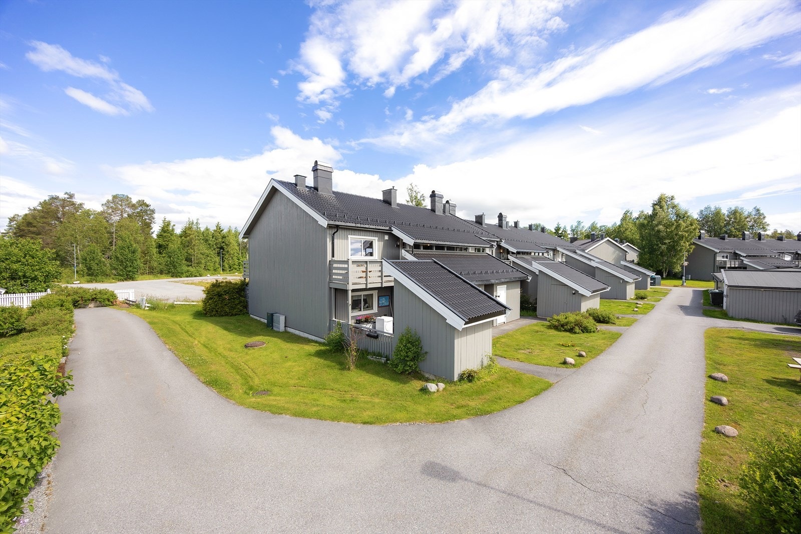 Tomten er pent opparbeidet med grøntarealer, beplantning, lekearealer og asfalterte adkomstveier. Galleribilde