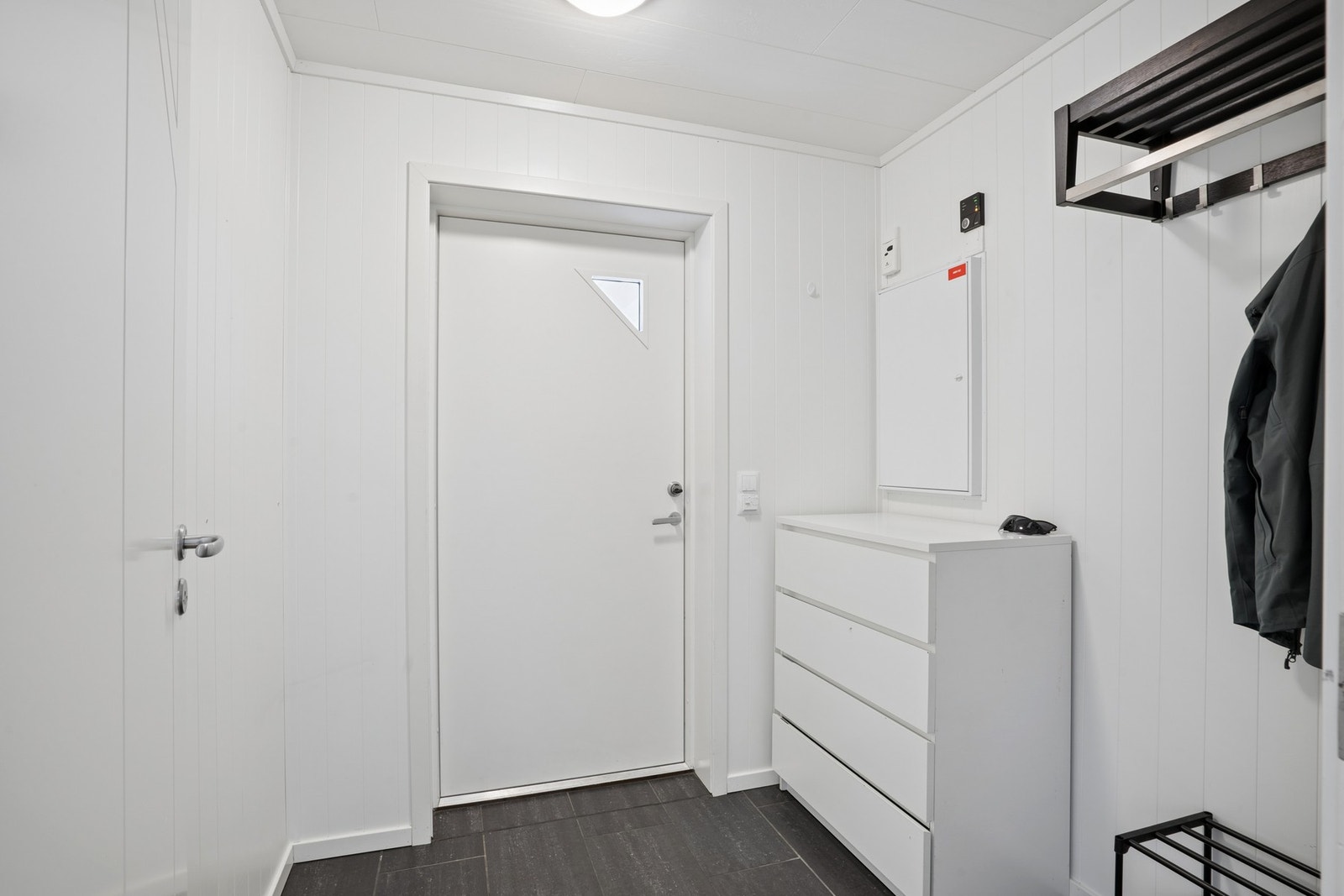 Entré med flislagt gulv og plass til oppbevaring av yttertøy. Galleribilde