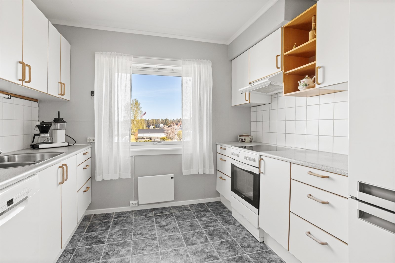 Kjøkkenet er et eget, praktisk rom med innredning med glatte fronter og benkeplate i laminat. Galleribilde