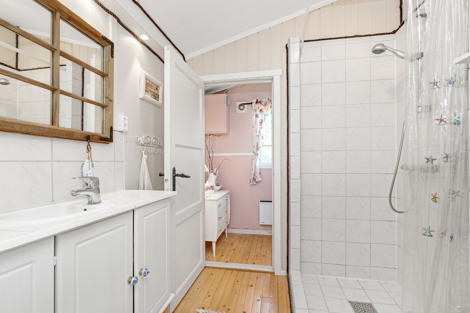 Badet er utstyrt med dusjhjørne med flislagt sone og servantinnredning. Galleribilde