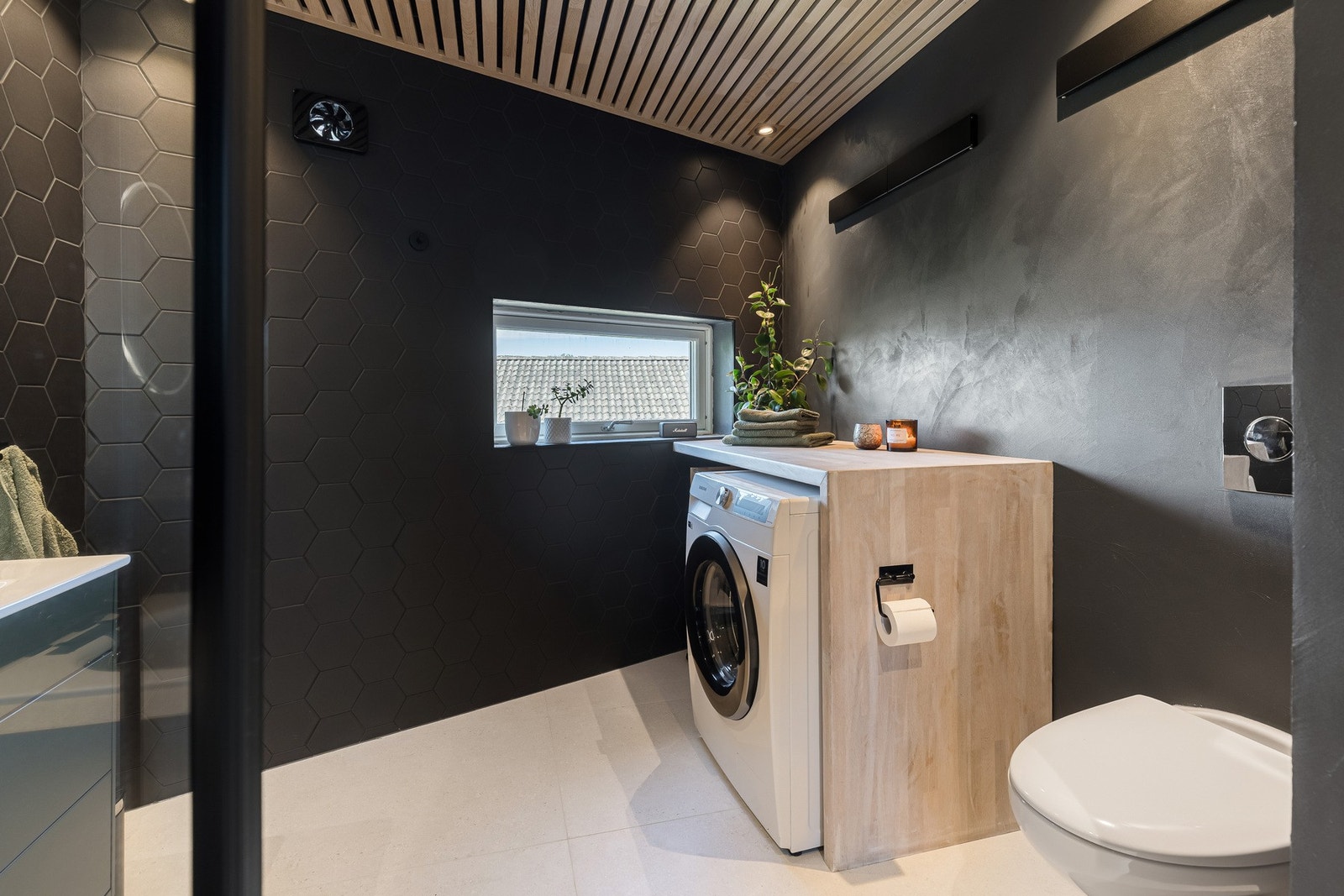 Badet er innredet med en praktisk vaskesone som gir god benkeplass og opplegg for vaskemaskin. Galleribilde