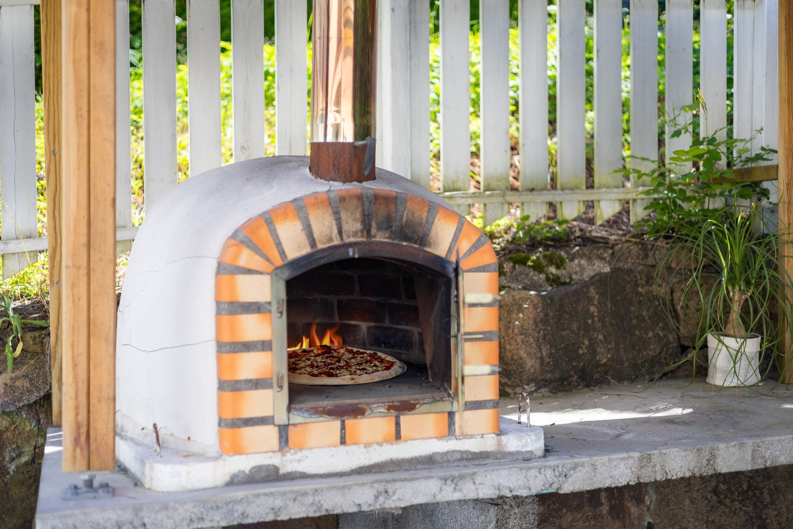 Den sjarmerende, vedfyrte pizzaovnen setter prikken over i-en og inviterer til hyggelige måltider og sosiale sammenkomster under åpen himmel. Galleribilde