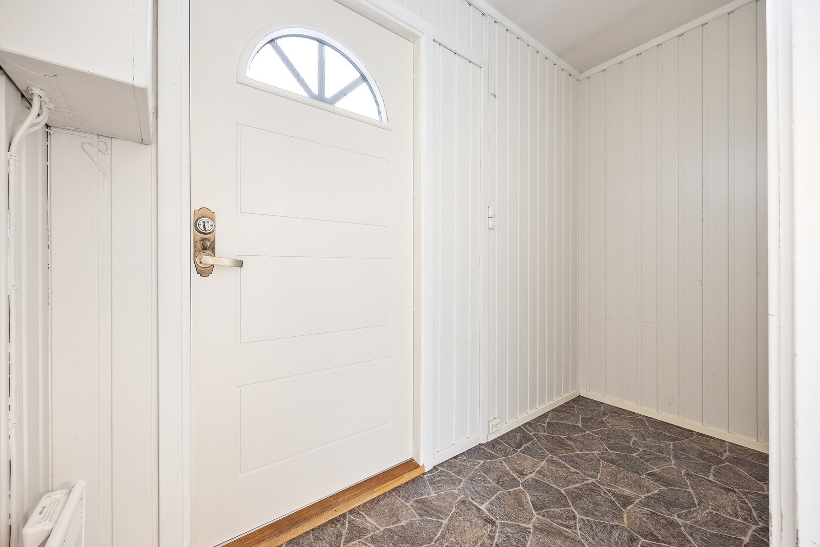 Entré med gulvbelegg og malt panel på veggene. Galleribilde