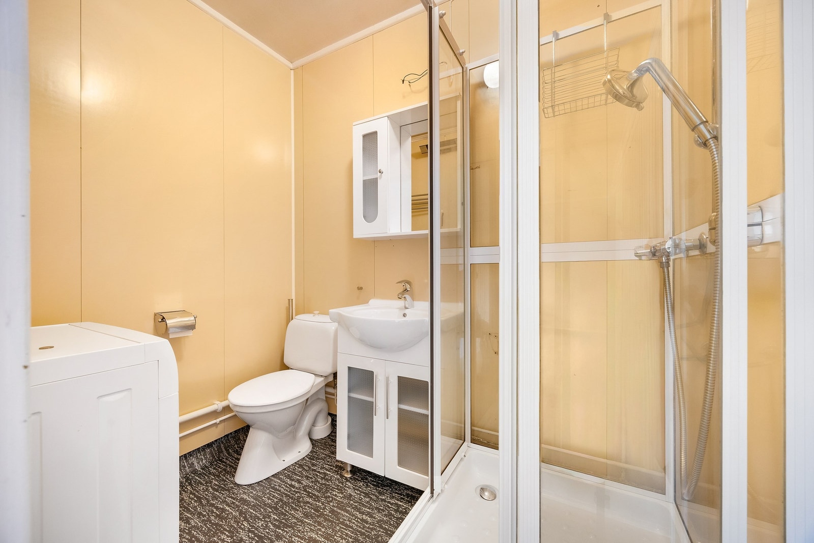 Badet er utstyrt med dusjkabinett, toalett og servantinnredning. Galleribilde