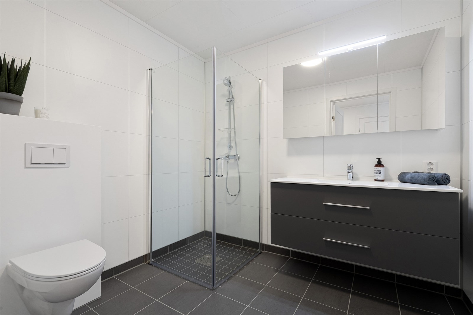 Badet er utstyrt med baderomsinnredning, vegghengt toalett og dusjhjørne Galleribilde
