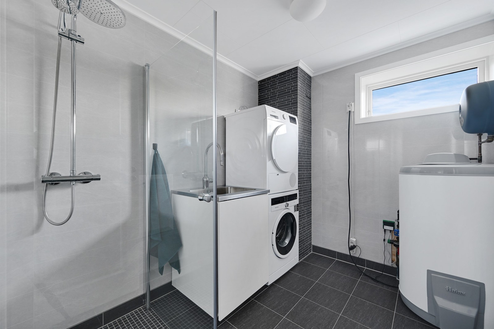 Bad/vaskerom har også utslagsvask, dusjvegger/hjørne og opplegg for vaskemaskin/tørketrommel. Galleribilde