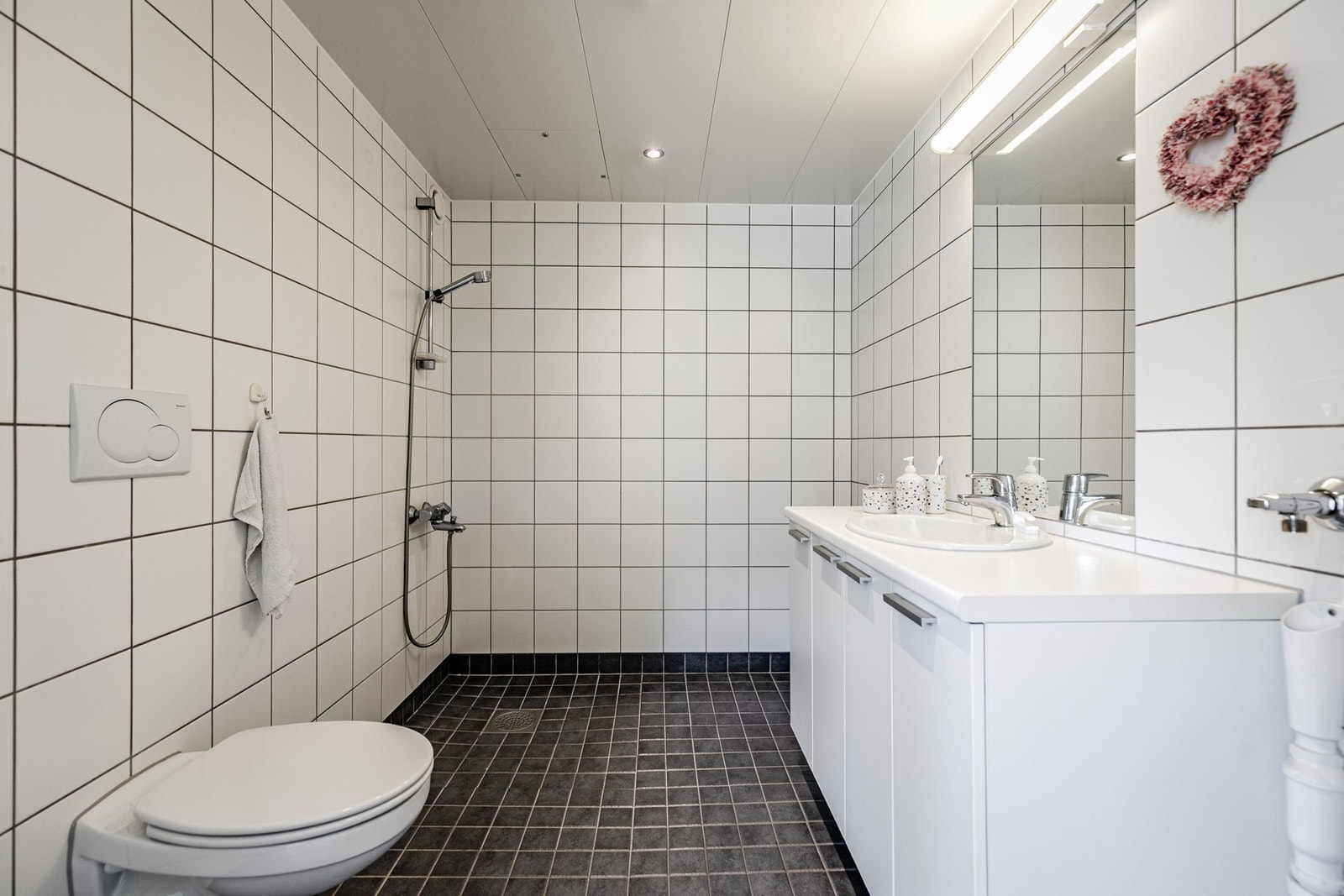Flislagt bad/wc med varmekabler i gulv og opplegg for vaskemaskin Galleribilde