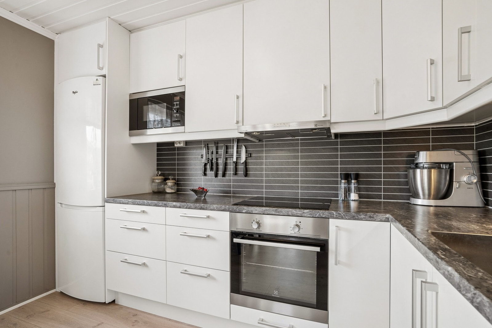Kjøkkeninnredning med glatte fronter og laminat benkeplate. Galleribilde