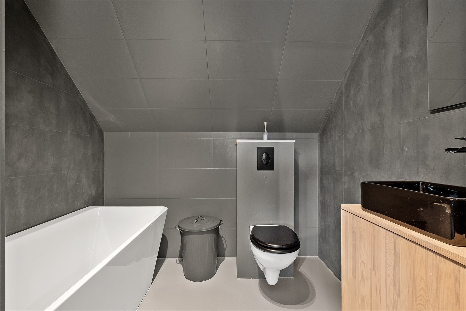Badet i 2. etasjen har et moderne uttrykk og er utstyrt med badekar, veggmontert wc, servantskap og mekanisk avtrekk. Galleribilde