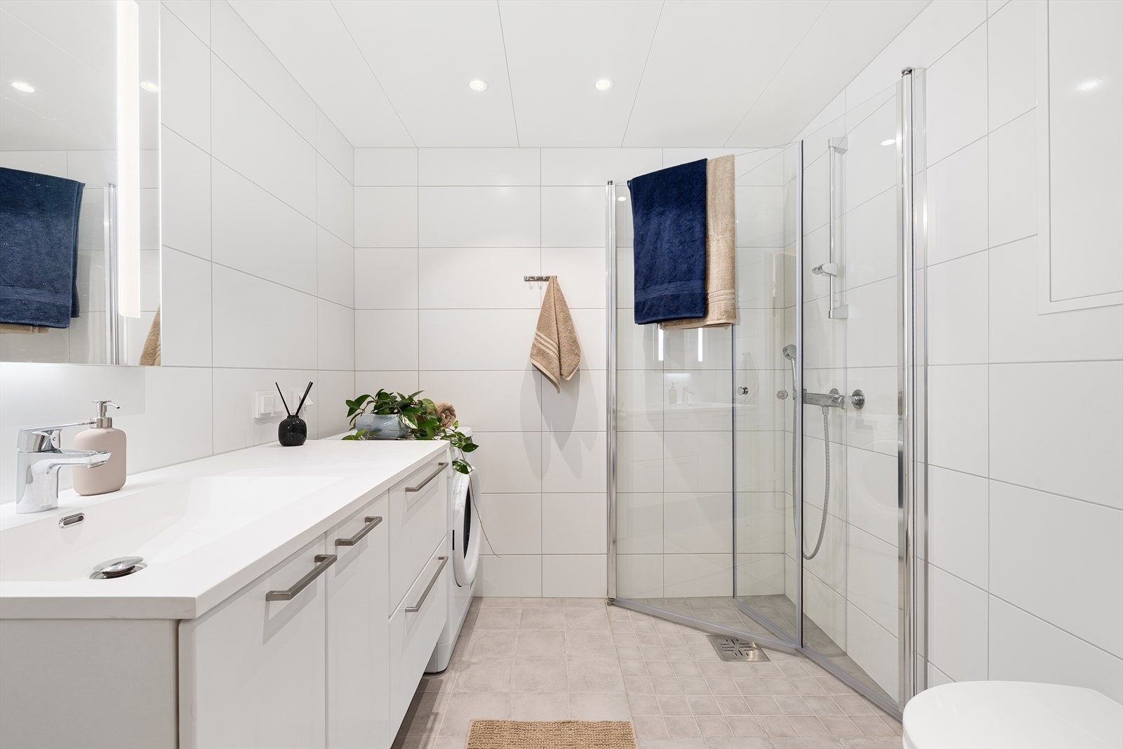Det 4 m² store badet fremstår som innbydende med helflisede overflater, behagelig gulvvarme og downlights i taket. Galleribilde