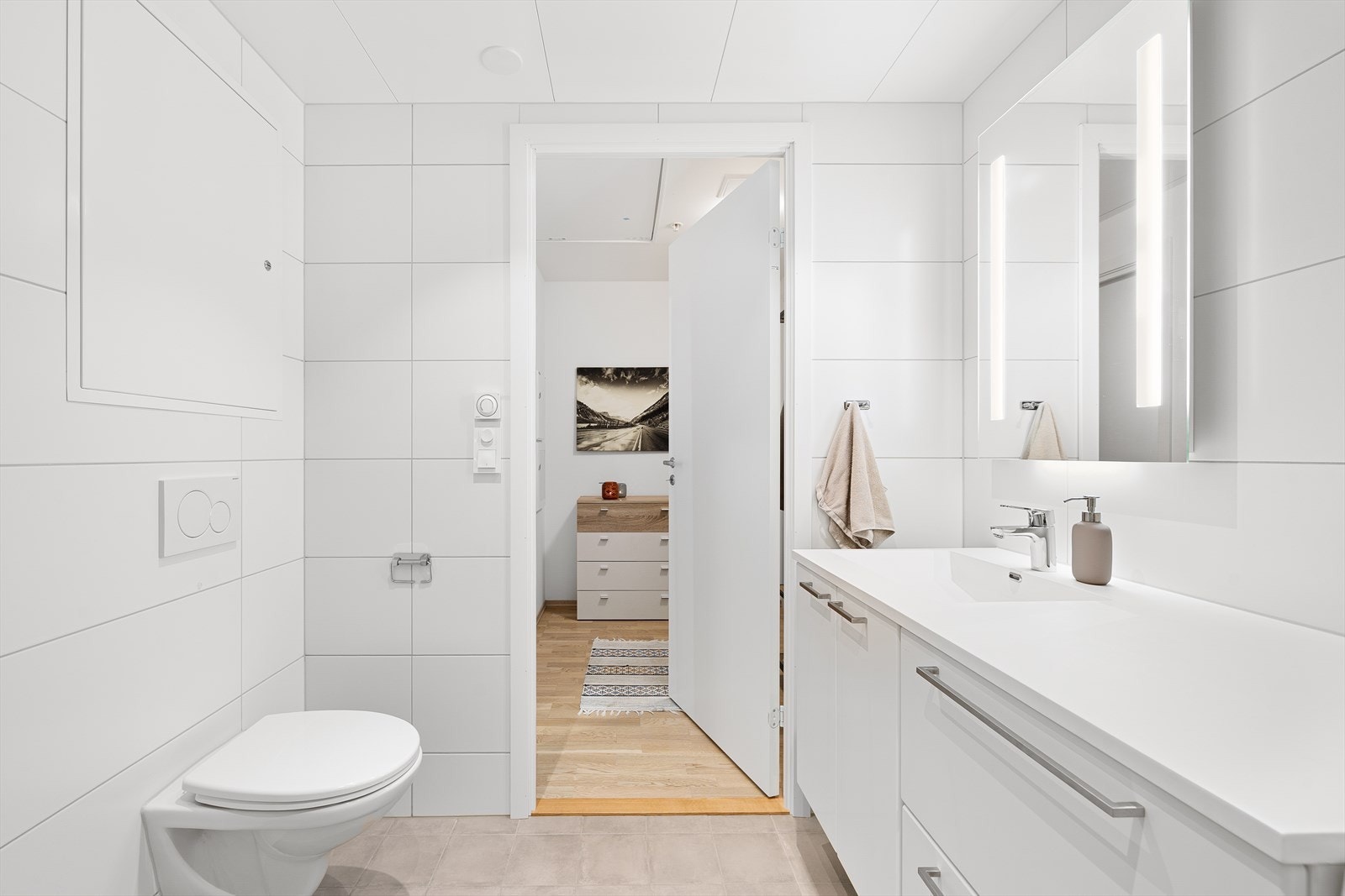 Badet er utstyrt med innfellbare dusjdører, mekanisk avtrekk, toalett, servant i skap og opplegg for vaskemaskin. Galleribilde